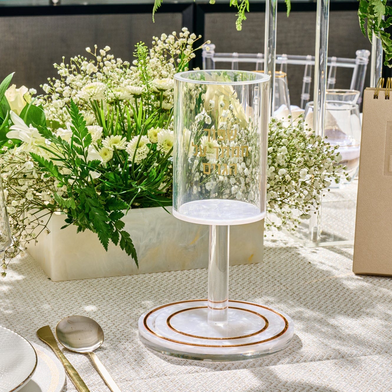 Pearlstone Kos Shel Eliyahu with white marble-look resin base and a clear lucite cup featuring gold Hebrew text.