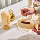 Beige marble-style resin match holder being used to strike a match on built-in striker – Waterdale Collection