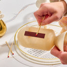 Beige marble-style resin match holder being used to strike a match on built-in striker – Waterdale Collection