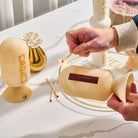 Beige marble-style resin match holder being used to strike a match on built-in striker – Waterdale Collection