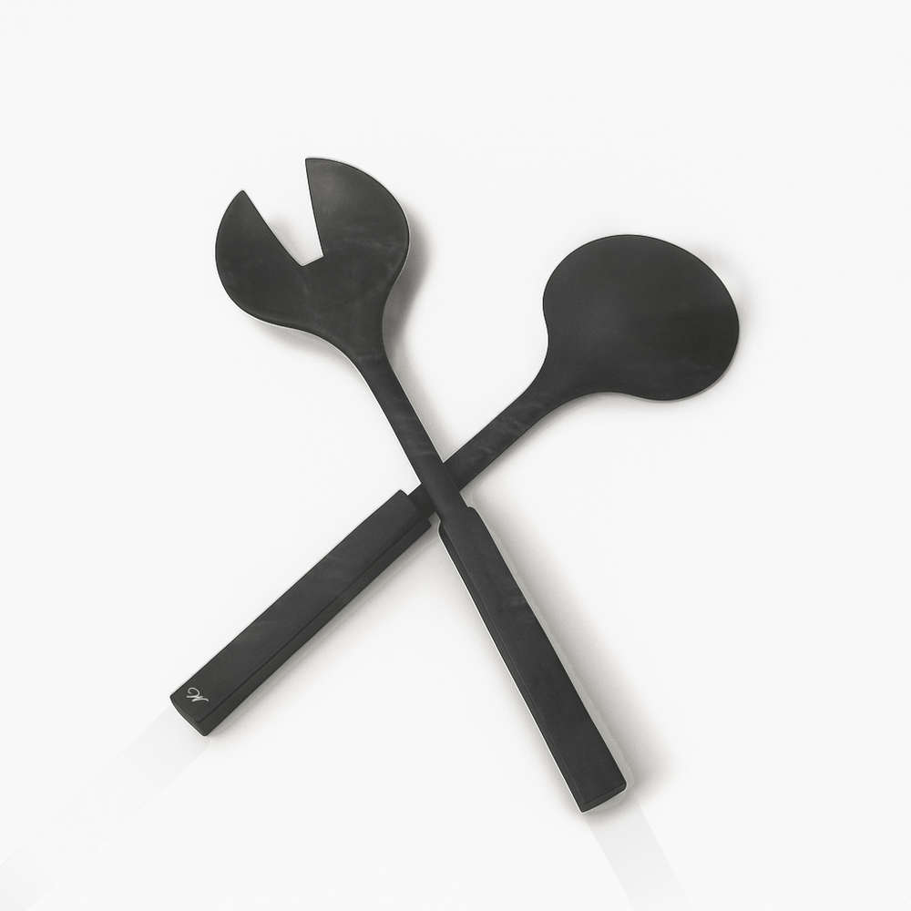 Two resin salad servers crossed on a white background