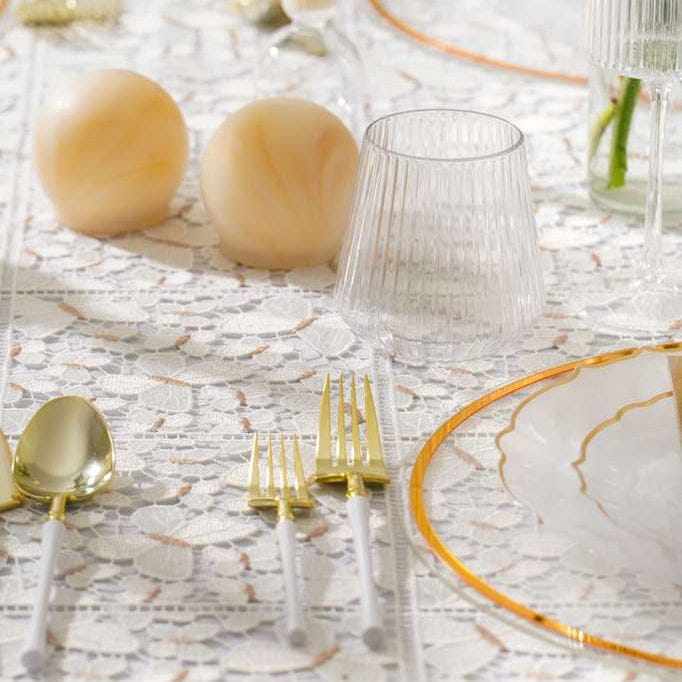Table setting with Resin gold salt shakers and gold and clear glassware on a textured tablecloth - Waterdale Collection