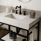 Matte gray resin washing cup shown on a modern white marble bathroom vanity next to a black three-hole widespread faucet - Waterdale Collection