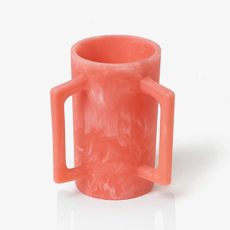Pink resin washing cup with two handles on a white background