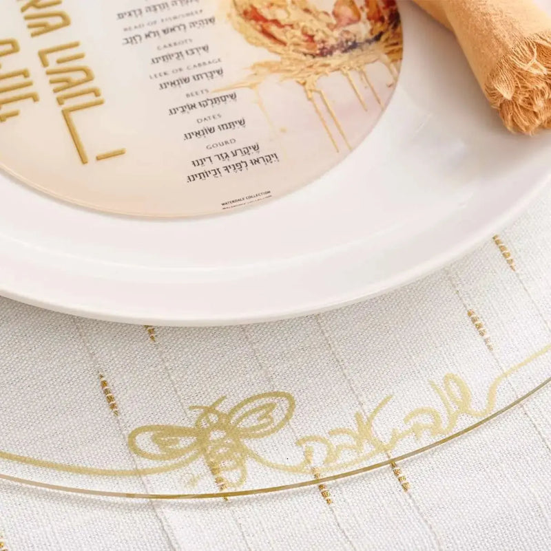 Rosh Hashanah rustic tablescape with gold-accented plates, place cards, and decorative elements arranged on white table linens by Waterdale Collection.