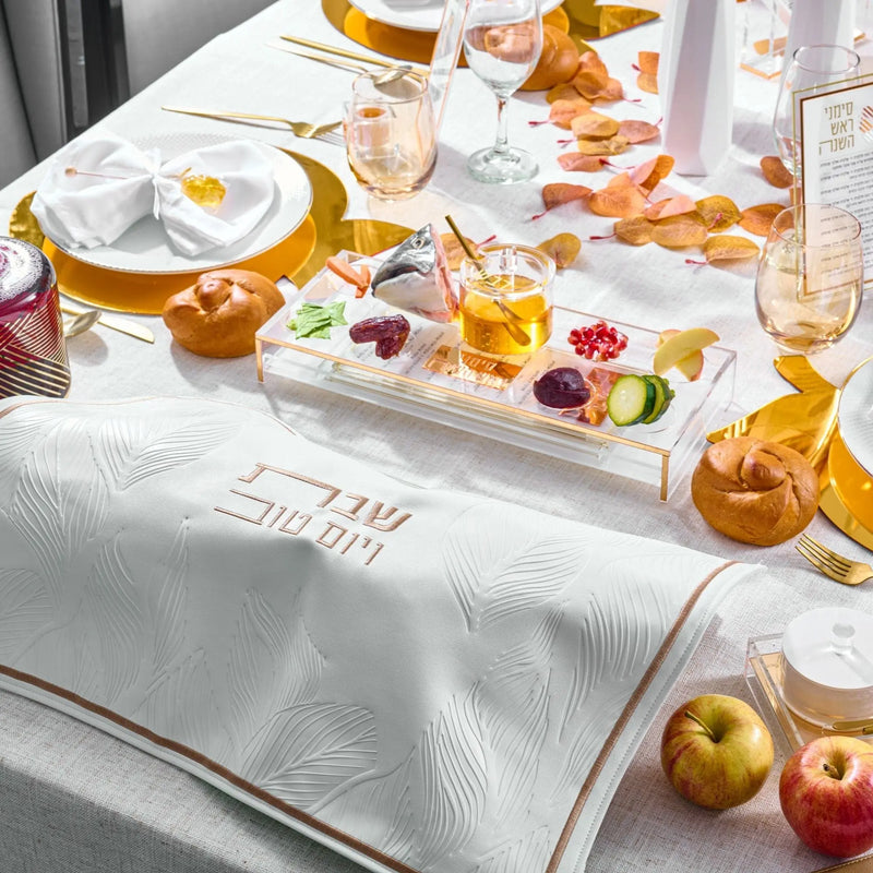 Rosh Hashanah 2025 Classic 2.0 tablescape featuring white linens, gold accents, honey dishes, and seasonal fruits arranged on a table setting.