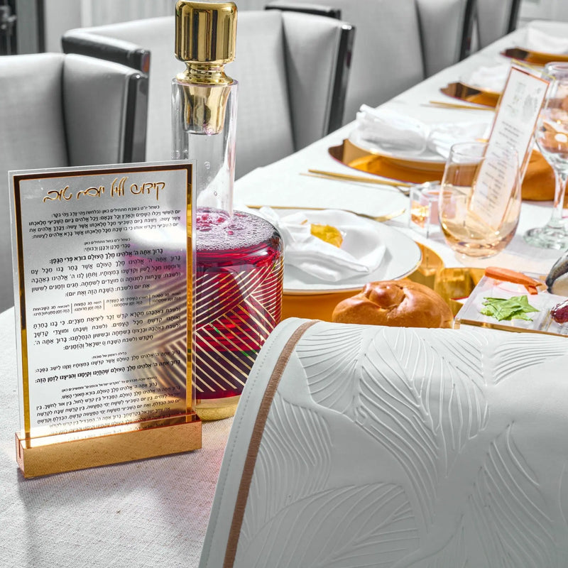 Rosh Hashanah 2025 Classic tablescape with painted place settings, gold accents, and honey jar centerpiece on gray table runner.