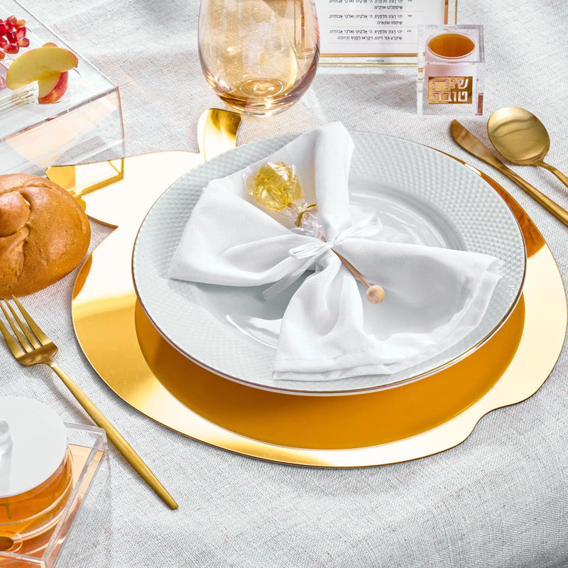 Rosh Hashanah Classic 2.0 tablescape with gold charger plates, white napkins, and gold flatware on gray linen, styled with challah and wine.