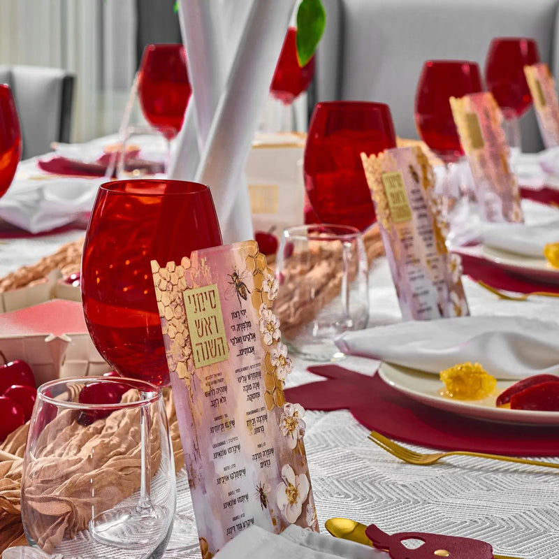 Rosh Hashanah 2025 painted tablescape with red candles, gold place cards, burgundy napkins, and white linens on formal dining table.