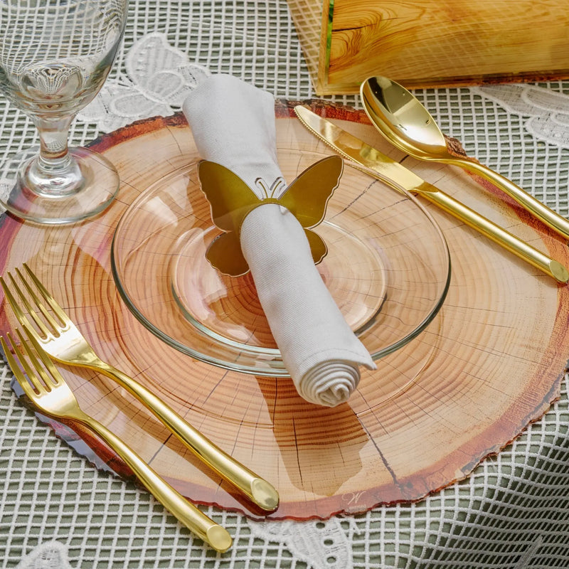 Shavuos wood tablescape with rose-toned placemats, gold cutlery, and white napkin rings on a festive holiday table setting.