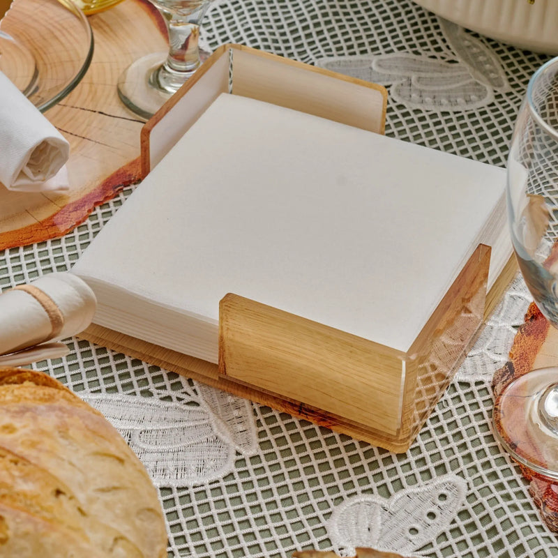 Wooden rolling pin and white notepad arranged on a patterned tablecloth with baking ingredients for Shavuos wood tablescape decoration.