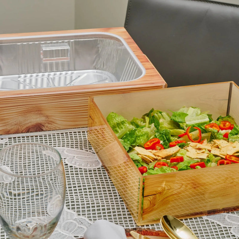 Shavuos wood tablescape with natural wooden boxes displaying fresh salad greens and vegetables, styled for holiday entertaining.