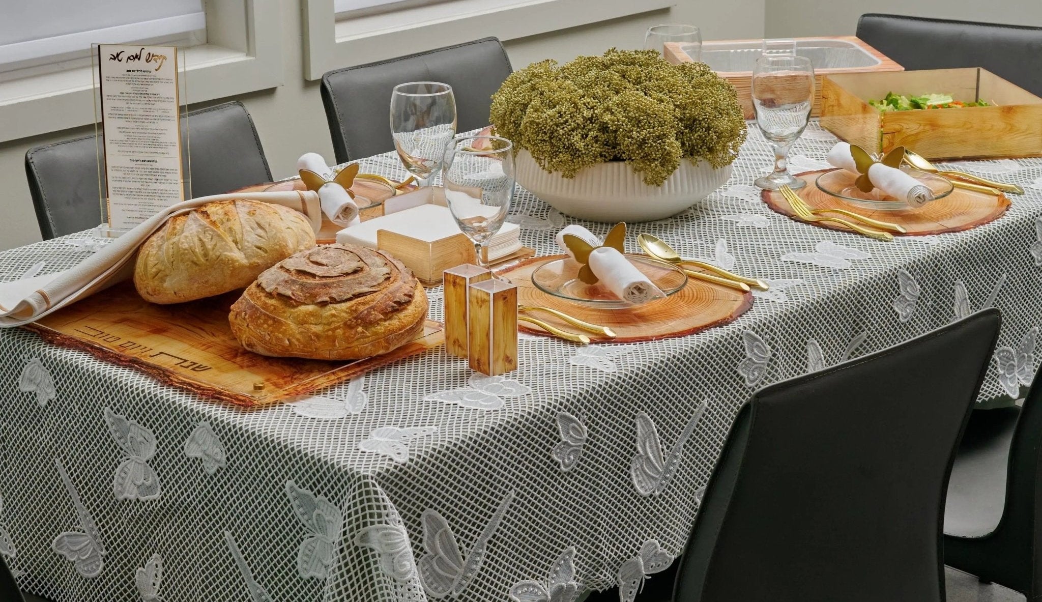 summer Dining table set with wood nature inspired bread, wine glasses, and a floral centerpiece in a modern kitchen.