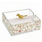 Square floral napkin holder with clear acrylic sides, gold botanical pattern, and decorative gold bird accent