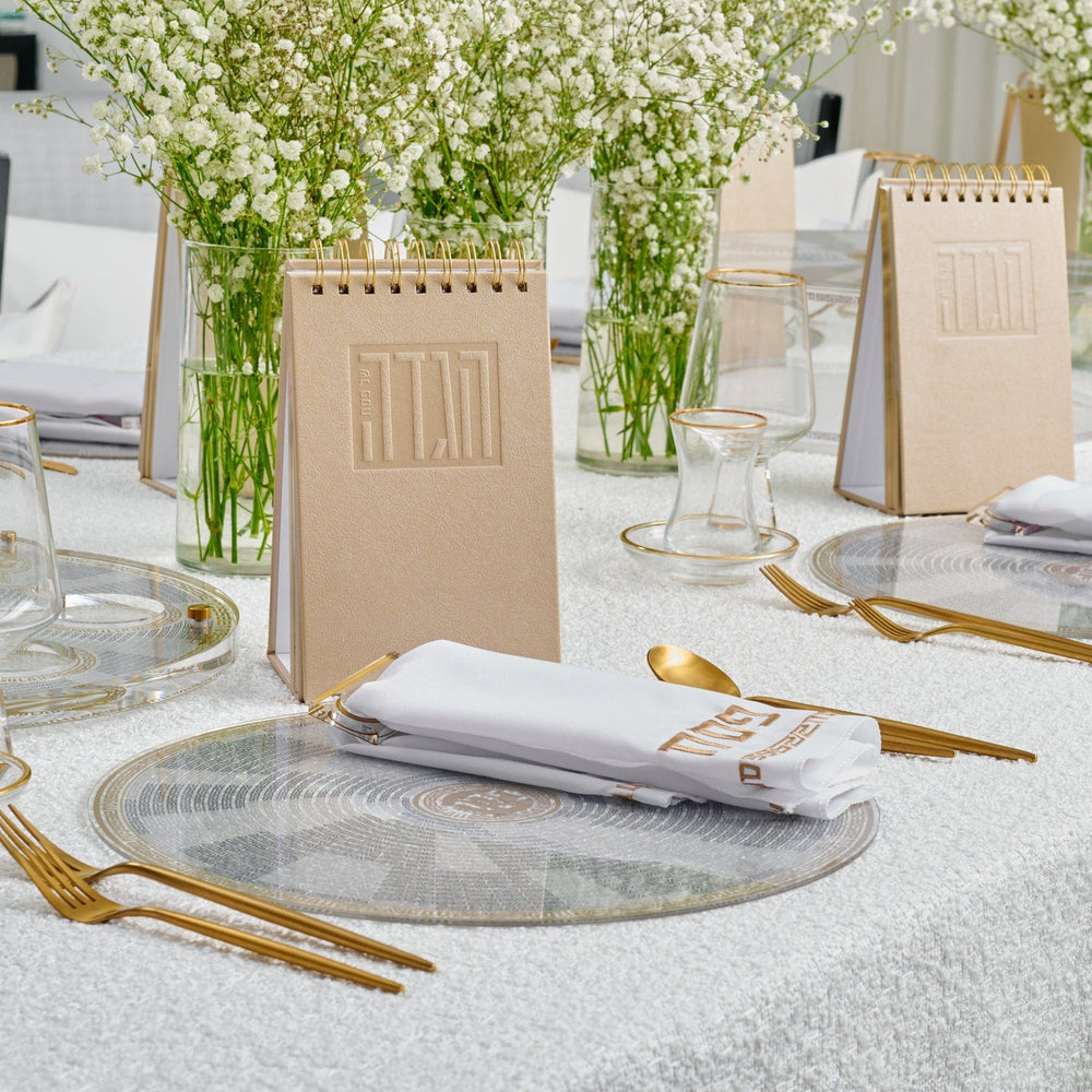 Gold Standing Leather Painted Haggadah on an elegant Shabbat table setting.
