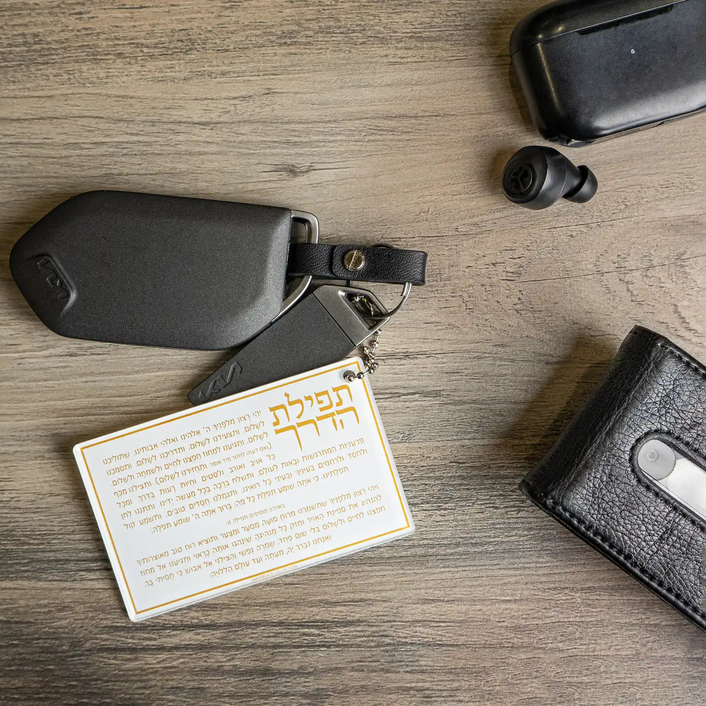 Lucite Tefilas Haderech Keychain on a lifestyle display.