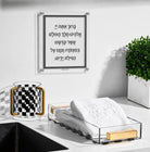 Traditional Al Netilas Yadayim acrylic plaque displayed above a bathroom sink alongside an Onyx checkered washing cup and acrylic guest towel holder — Waterdale Collection
