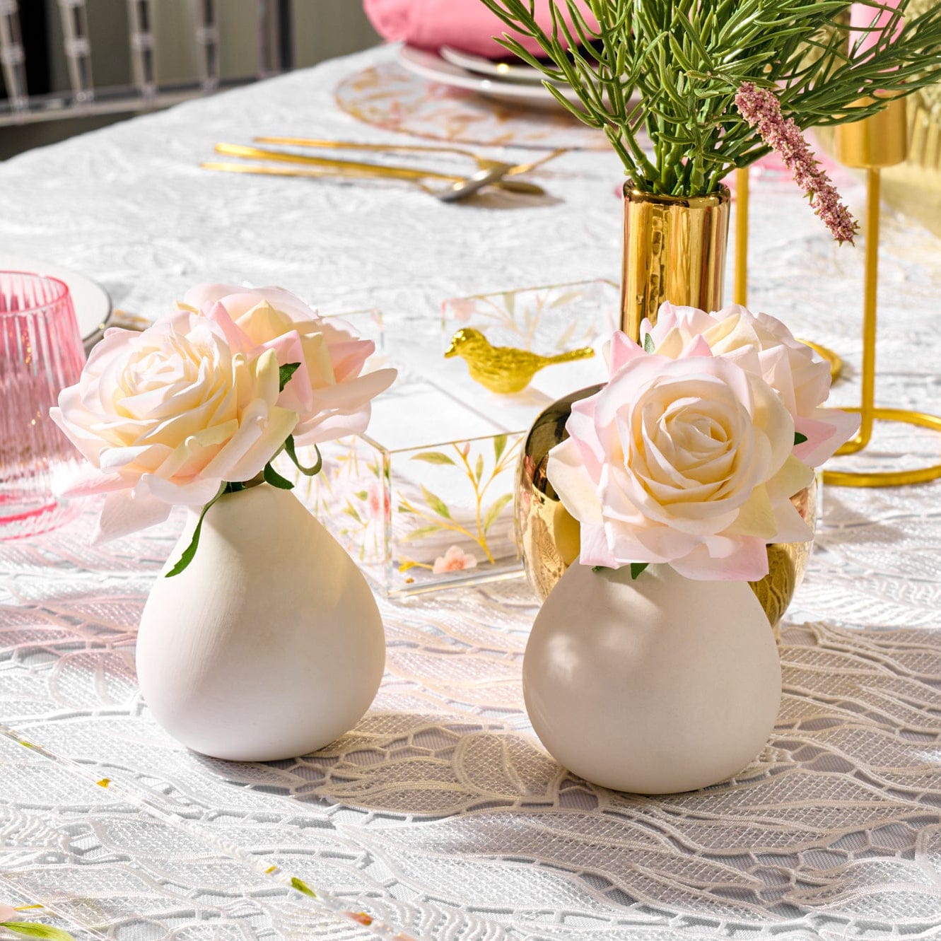Minimalist white faux floral arrangement in a modern clear teardrop glass vase, featuring realistic silk flowers for a minimalist home decor.
