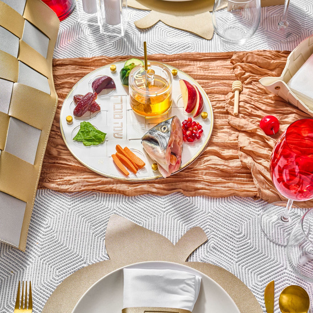 Gold Woven Simanim Tray with fish, honey dish, and other items on top of it in a Rosh Hashanah table setting