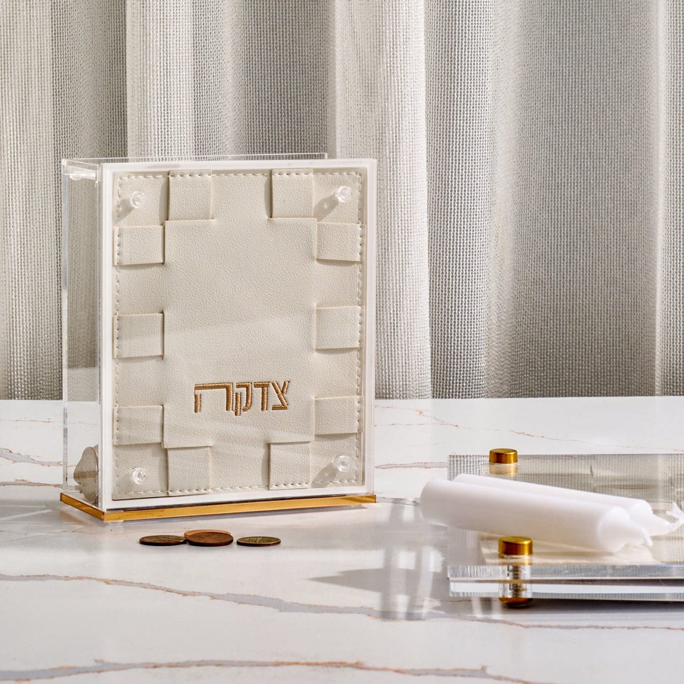 Woven Tzedakah Box in clear acrylic with cream woven design and gold “Tzedakah” lettering, modern Judaica charity box for Shabbat table, Jewish home decor tzedakah holder gift.
